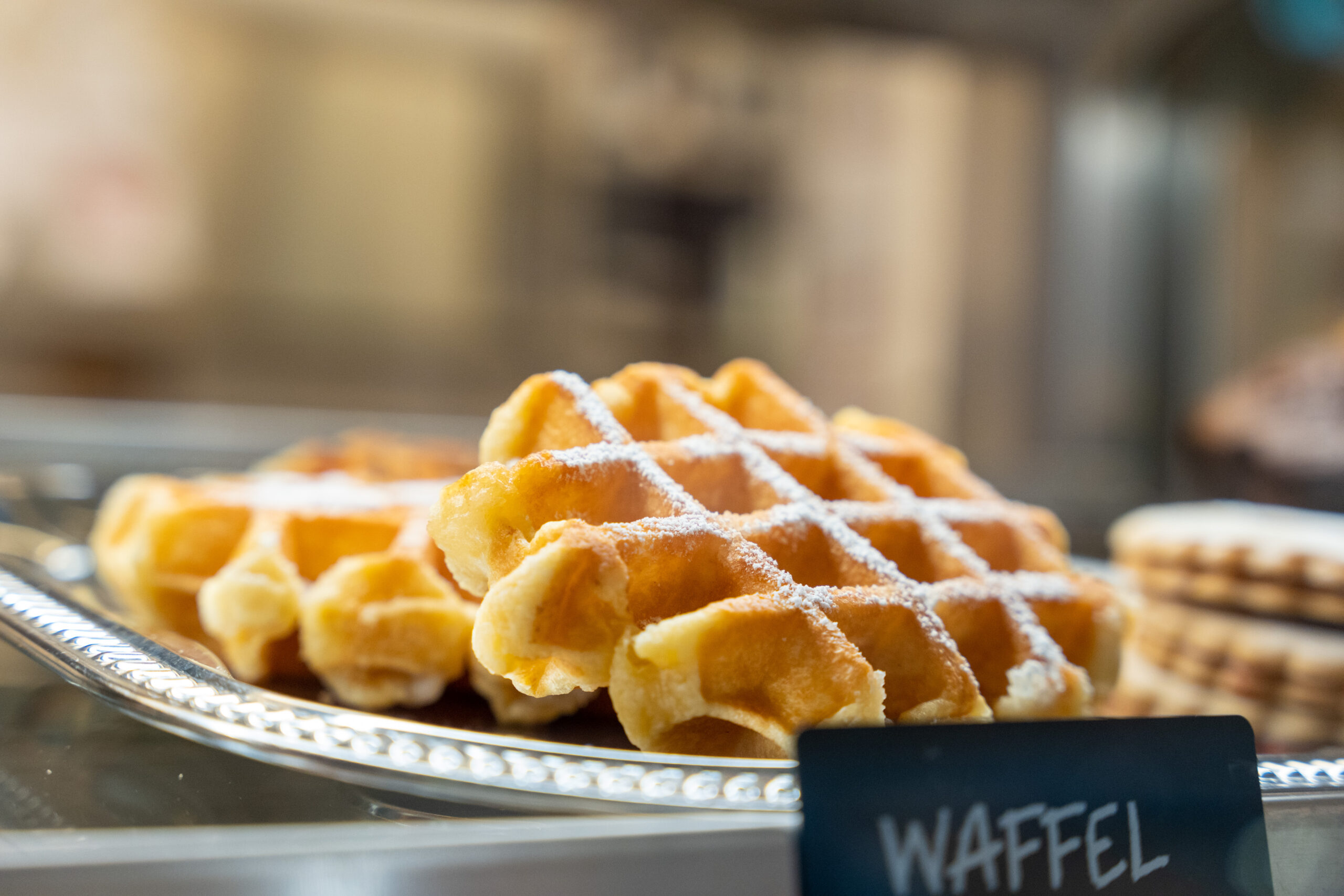 Waffeln mit Puderzucker in der Speisenauslage von Audimax Wien.