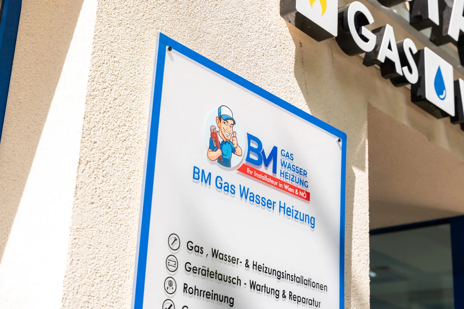 Firmenschild von BM Gas Wasser Heizung am Eingang.