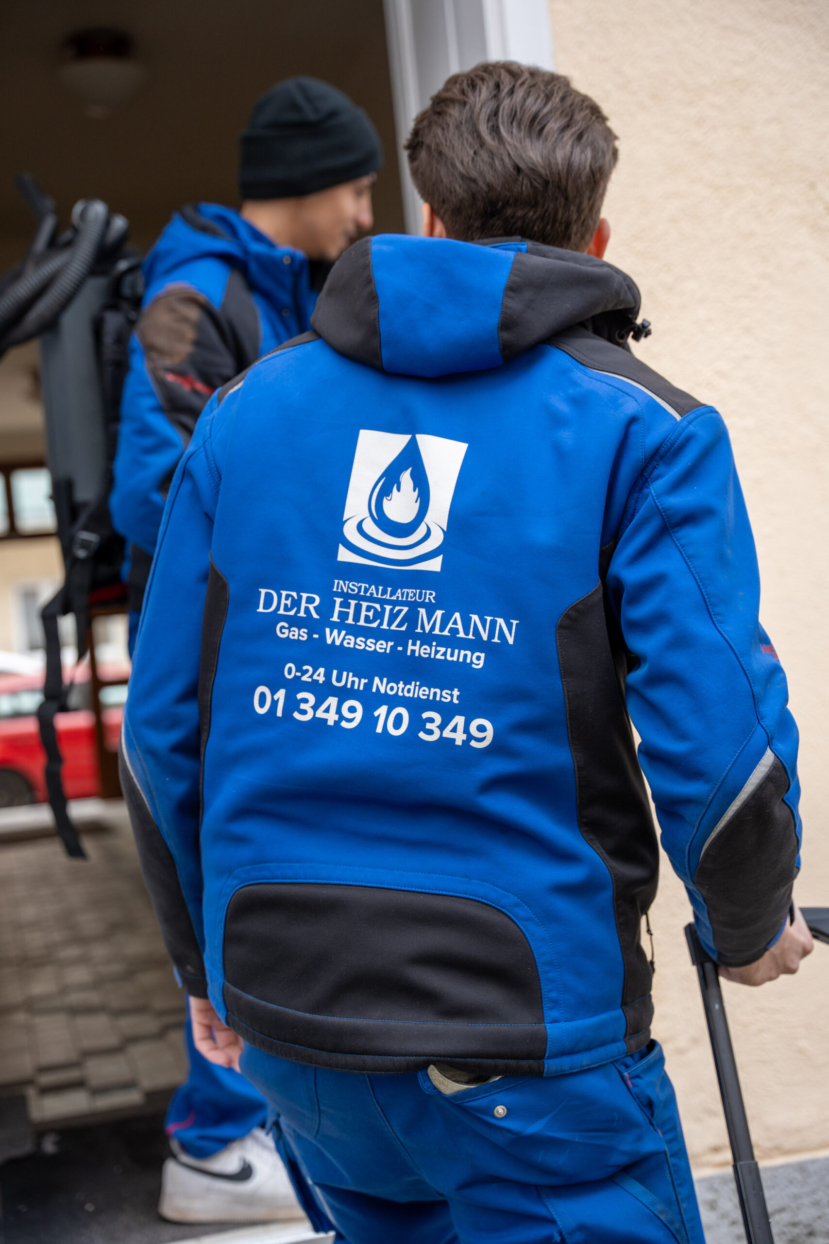 Mitarbeiter von Der Heiz Mann mit Logo auf der blauen Arbeitsjacke.