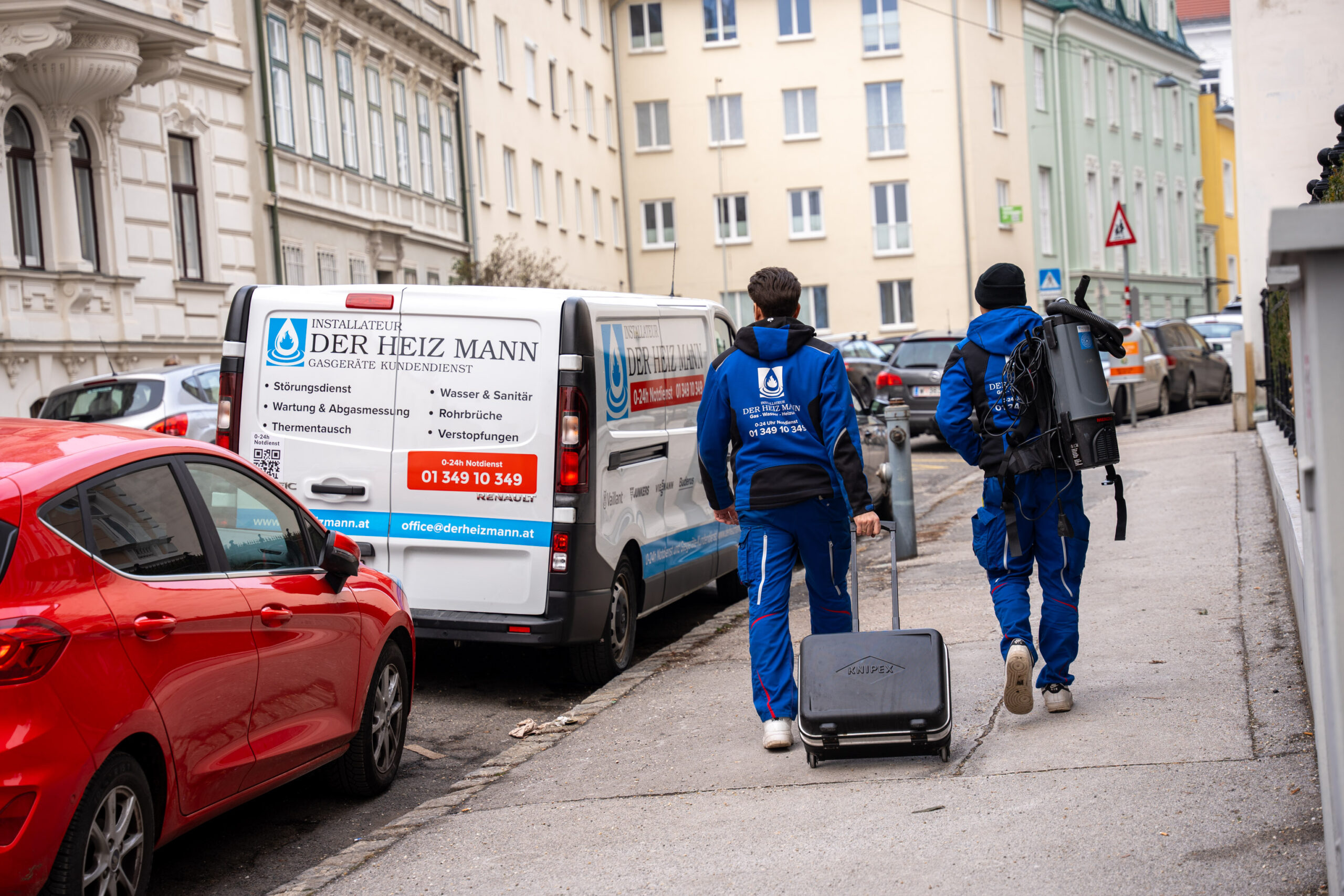 Zwei Mitarbeiter von Der Heiz Mann mit Werkzeug auf dem Weg zum Einsatz.