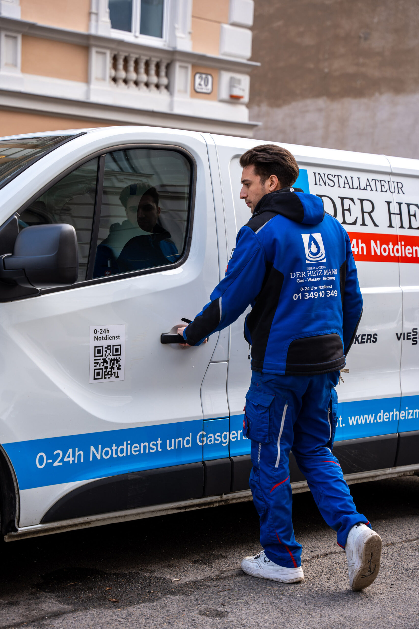Mitarbeiter öffnet die Tür eines Einsatzfahrzeugs von Der Heiz Mann.