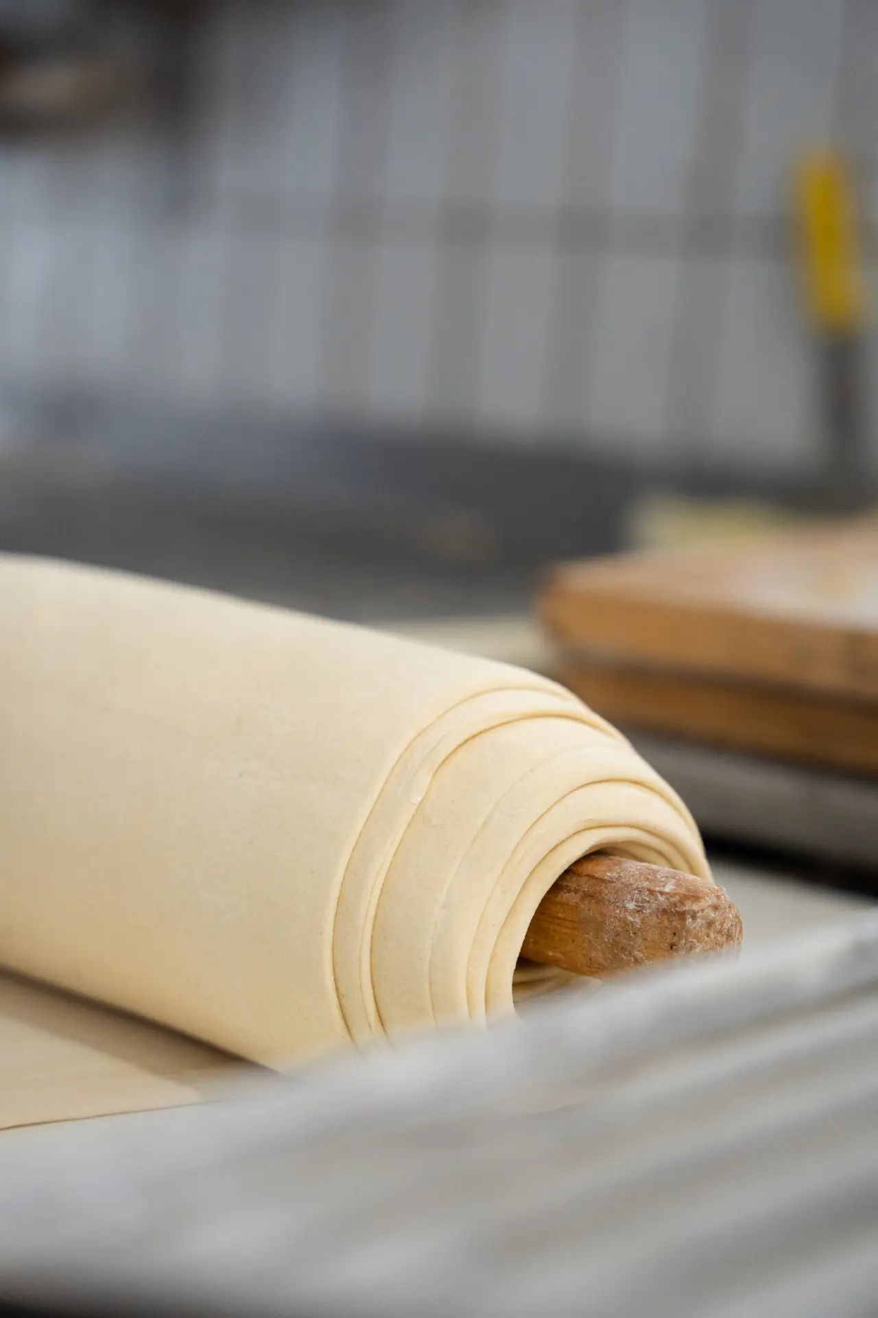 Ausgerollter Teig auf einem Nudelholz in der Prindl-Backstube.