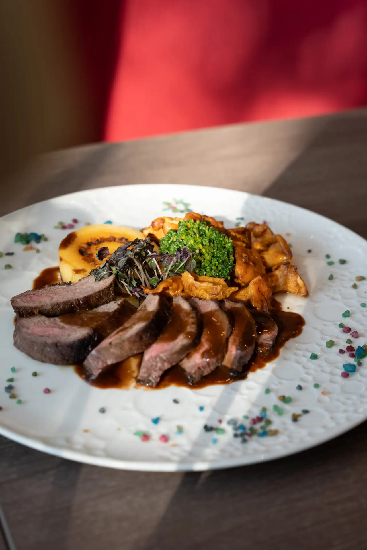Fleischgericht mit Beilagen im natürlichen Licht des Prindl-Restaurants.