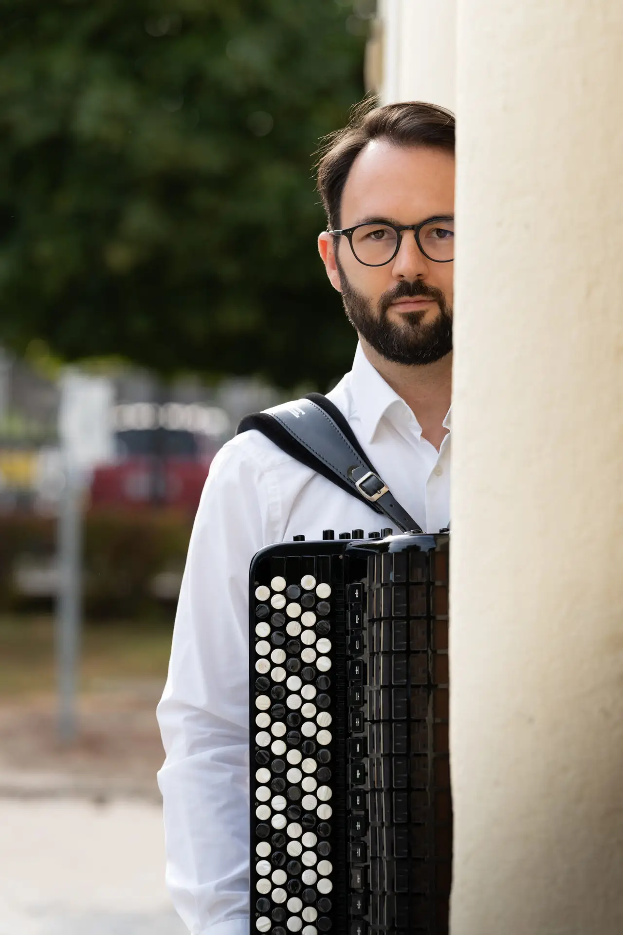 Porträt des klassischen Akkordeonisten Nikola Djoric an einer Steinsäule.